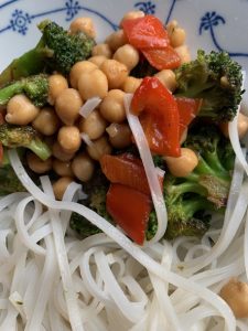Kichererbsen, Brokkoli, rote Paprika und Asia-Nudeln auf Teller mit Zwiebelmuster